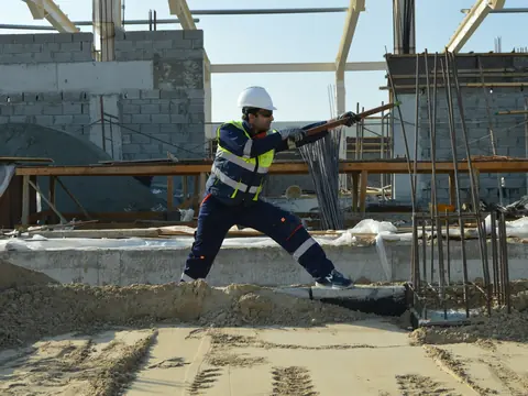 Arbeiter räumt eine Baustellenfläche auf