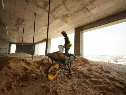 Innenraum im Rohbau mit Sand und Schubkarre