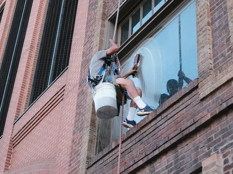 Fensterreinigung an einer Backsteinfassade