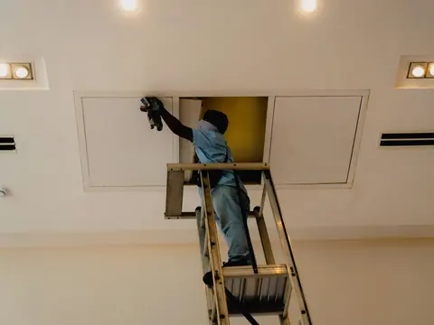 Arbeiten an einer Deckenöffnung auf der Leiter