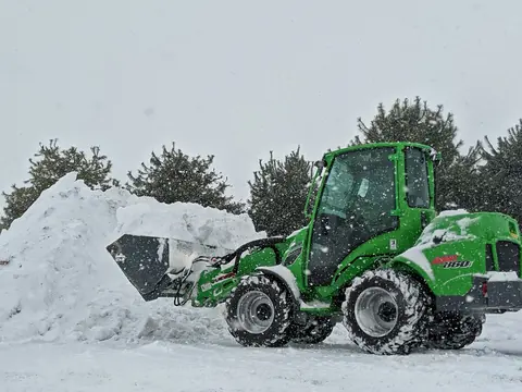 Kompaktlader räumt Schnee von einer Fläche